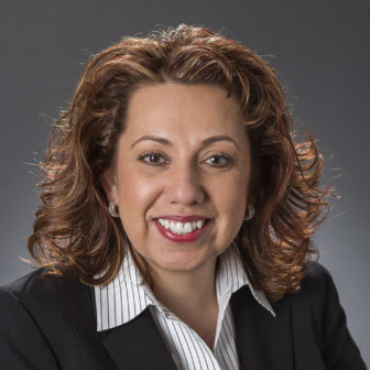 adolescent development: Sandra Gasca-Gonzalez (headshot), vice president of Center for Systems Innovation at Annie E. Casey Foundation, smiling woman with red shoulder-length hair, earrings, black jacket, black and white striped blouse 