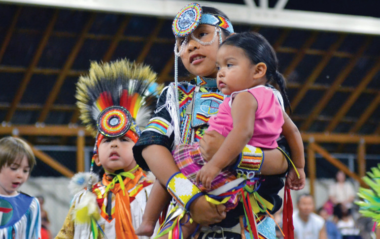 The Native American Youth and Family Center (NAYA) celebrates the cultural identity of its youth and families. Here, children in traditional regalia take part in a powwow.