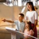 Museum project support grants: mom and children looking at museum exhibit excitedly