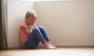 child abuse, child welfare, foster care:Unhappy Child Sitting On Floor In Corner At Home