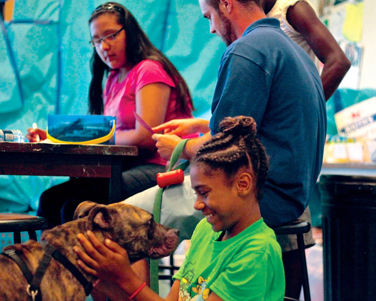 Horizons student Niya plays with Ollala, her teacher’s dog, who helped star in the children’s PSA for the local humane society, created as part of a hands-on learning activity during the summer program.