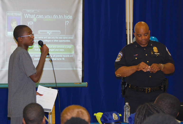 An Indianapolis police officer and a young person engage in Juvenile Justice Jeopardy at the department's inaugural kickoff of the game at the Ransburg YMCA in Indianapolis.
