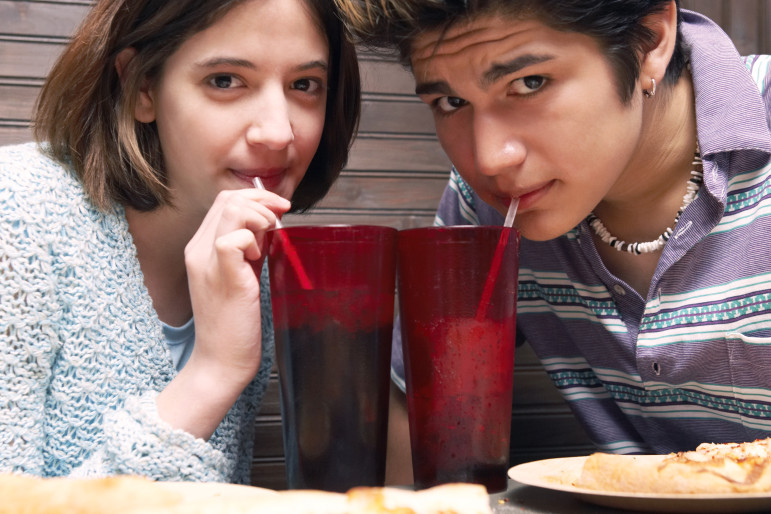 Teenage couple drinking soft drinks