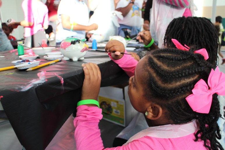 Amya Howard, 5, paints a piggy bank at the Lights On Afterschool event Thursday at Raymond Recreation Center in Washington, D.C.