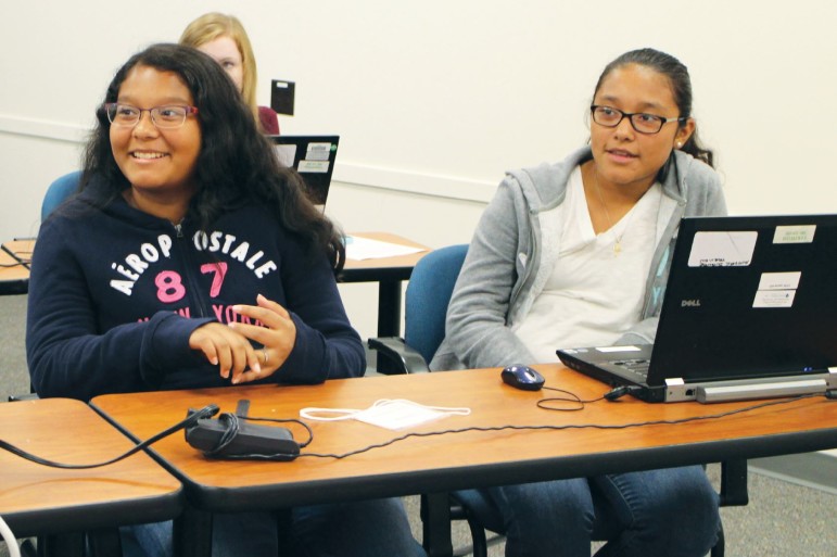Sisters Vanessa Peñarrieta, 12, and Jaquelin Peñarrieta, 13, listen to Girls Who Code instructors as part of the club's 40 hours of instruction provided to participants.