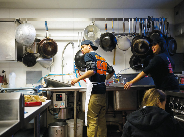 Other young people in the UTEC program work in the kitchen at UTEC or at a mattress recycling plant in Lowell, Massachusetts.
