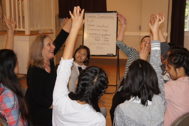 Instructor Ruth Schowalter leads the Creative Communication Class in a hand dance. Movement helps "unlock" the language for these students of English as a second language, she says. Most of the teens fled their home countries and have been resettled in the United States.
