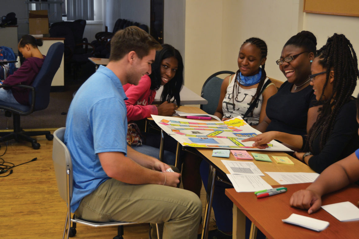 Moneythink mentor Johnny Sullivan plays a financial literacy board game with students at Hirsch Metropolitan High School in Chicago where the students practice budgeting and saving to learn how to better deal with life's unexpected financial hurdles.