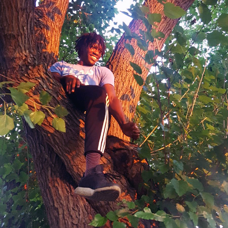 Dimitrius Eliza, Camden, New Jersey, sits in tree at summit on food systems, inequality in Greensboro, North Carolina.