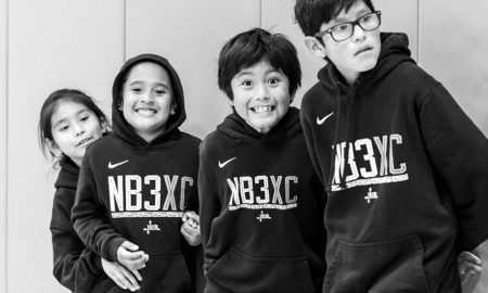 native youth sports and physical activity grants; four native youth in matching hoodies smiling at camera