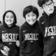 native youth sports and physical activity grants; four native youth in matching hoodies smiling at camera
