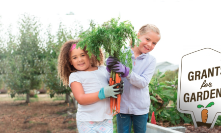 youth educational edible garden grants; two young girls in garden with freshly harvested carrots