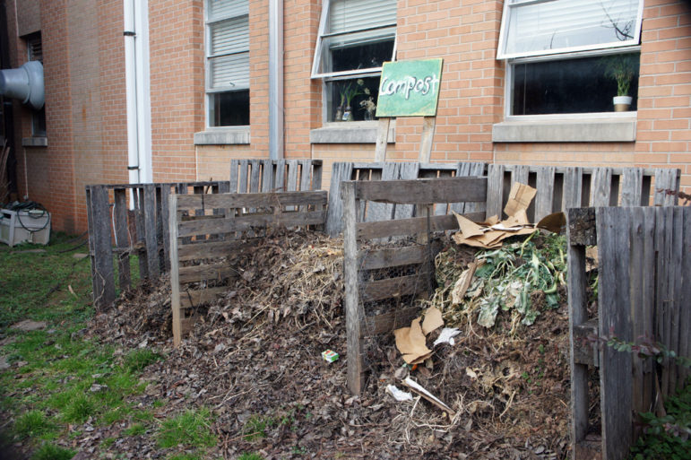 Open compost bins sit at side of building.