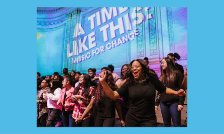 On Carnegie Hall stage, casually dressed high school students smile, sing.