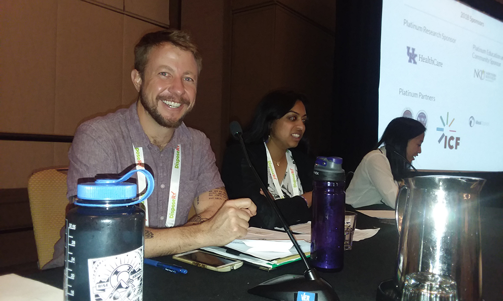 Rise Above Colorado: Seated at presenters' table by slide screen left to right: Jonathan Judge, Kavitha Kailasam and Mae Thompson 