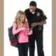 GRANT: youth-law-enforcement-interaction-research-grants police woman& yong girl with backpack stand together reading a book