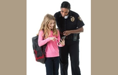 GRANT: youth-law-enforcement-interaction-research-grants police woman& yong girl with backpack stand together reading a book