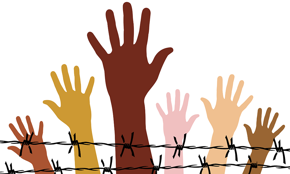 6 hands and lower arms of different colors (dark brown, light brown, yellowish, pinkish white, beige) reach out behind barbed wire