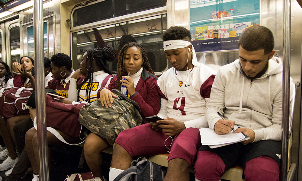 football players and others riding in a subway