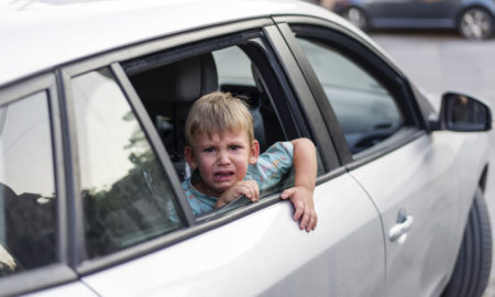 Foster care: child separated from one parent leaving in a car, sad and crying