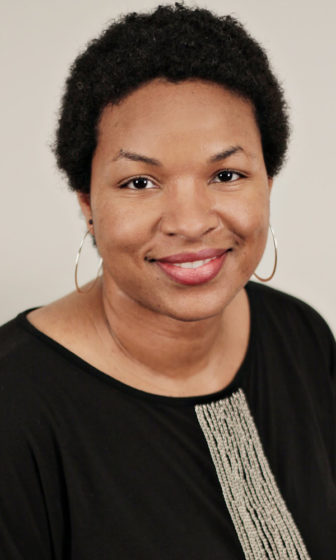 Microaggressions: Keonya Booker (headshot), assistant professor of teacher education at College of Charleston, smiling woman in earrings, black top.