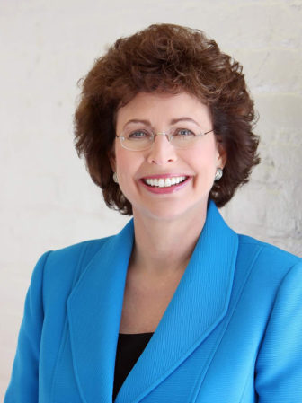 Mentoring: Pam Iorio (headshot), President/CEO of Big Brothers Big Sisters of America, smiling woman with short brown curly hair, earrings, glasses, bright blue suit.