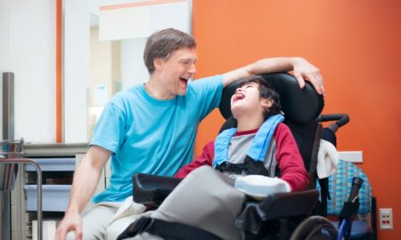 children/youth with disabilities grants: man laughing with disabled child