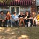 Video: Eight smiling young people sit next to each other on the street of small town.