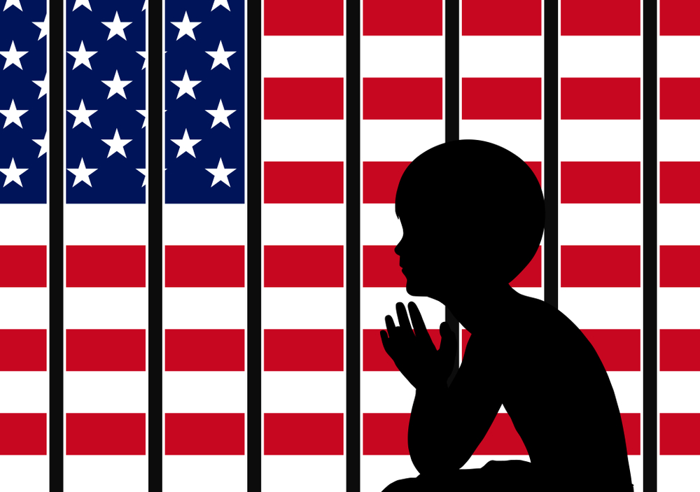 immigration: Silhouette of child behind bars with American flag on other side.