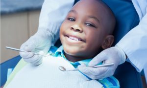 school-based dental health care grants, young child smiling at dentist