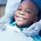 children's dental care grants, young child smiling at dentist