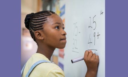 inner city education grants, young black female student doing math on white board