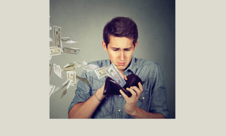 scarcity mindset: Sad man looking at his wallet with money dollar banknotes flying out away