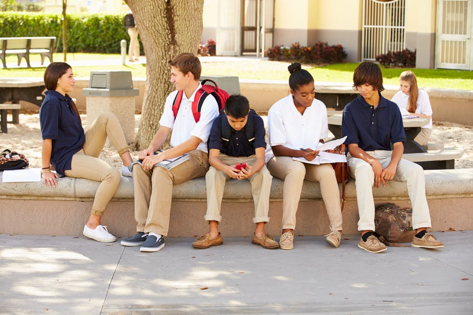 social trust: 6 students sit outside, talking to each other.
