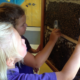 educational bee hive grants; two young girls studying beehive