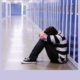 social and emotional learning: student sitting on floor of school hallway against lockers, head buried on knees.