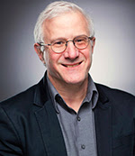poverty: Steve Goodman (headshot), founder of Educational Video Center, smiling man with white hair, glasses, blue shirt, dark jacket