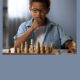 TAG: Little boy thinking about chess move