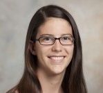 mentoring: Elizabeth Raposa (headshot), assistant professor at Fordham University, smiling woman with long brown hair, glasses, black and white top