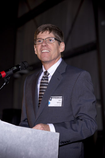 JSA: Ken White (headshot), CEO of Junior State of America, man in dark suit, white shirt, patterned tie speaking at microphone