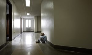 child abuse and neglect prevention, treatment grants; sad child sitting in hallway