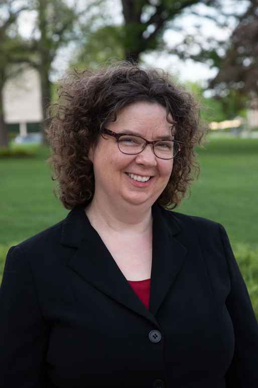 Transgender: Amy Miller (headshot), legal director of ACLU of Nebraska, smiling woman with short brown curly hair, glasses, dark jacket.