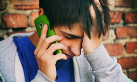 youth peer lines: Sad Young Man with Cellphone on the Brick Wall Background