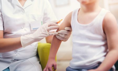 child vaccination coverage report; child getting a vaccine shot