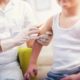 child vaccination coverage report; child getting a vaccine shot