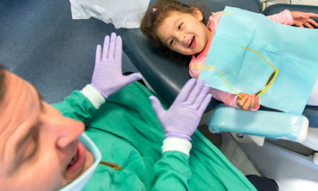 community child dental care grants; happy child smiling in dentist's chair