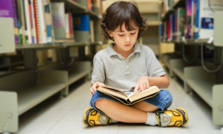 community reading program grants; child reading on floor between bookshelves
