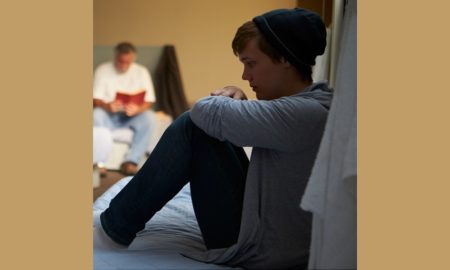 homeless youth basic services center program grants; youth sitting on bed at homeless shelter
