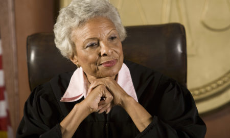 sex trafficking: Portrait of happy senior judge sitting in courtroom Headshots: