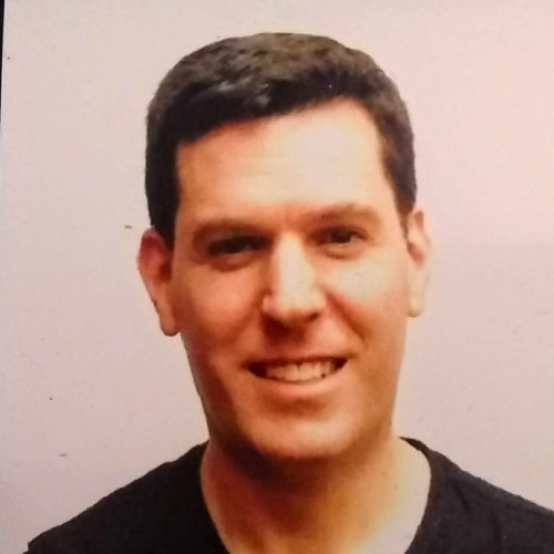 Joshua Rovner (headshot), senior advocacy associate at Sentencing Project, smiling man with short dark hair, dark top